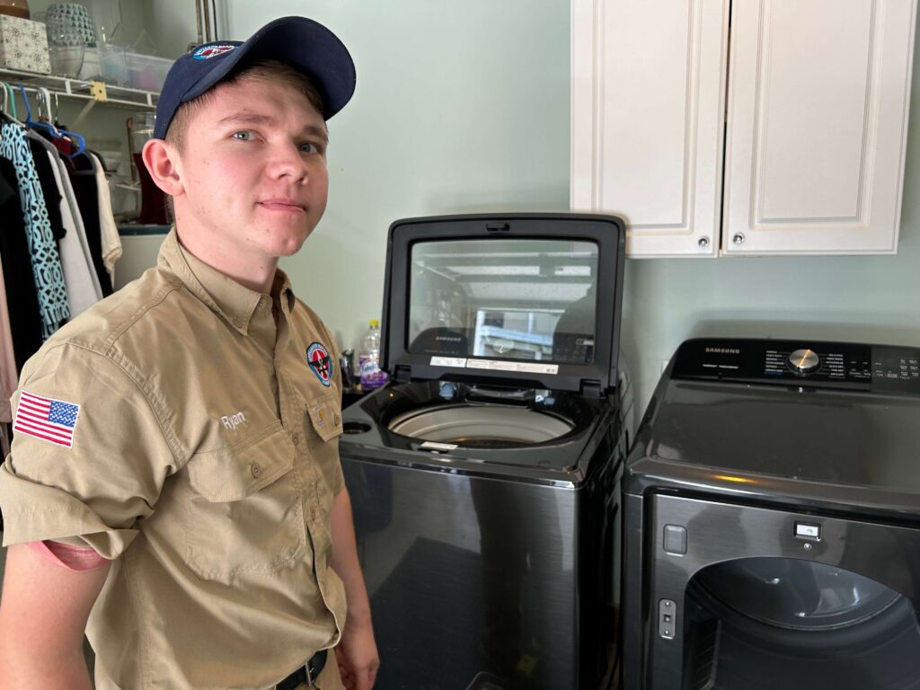 Appliance Repair American technician beside a Samsung washer and dryer