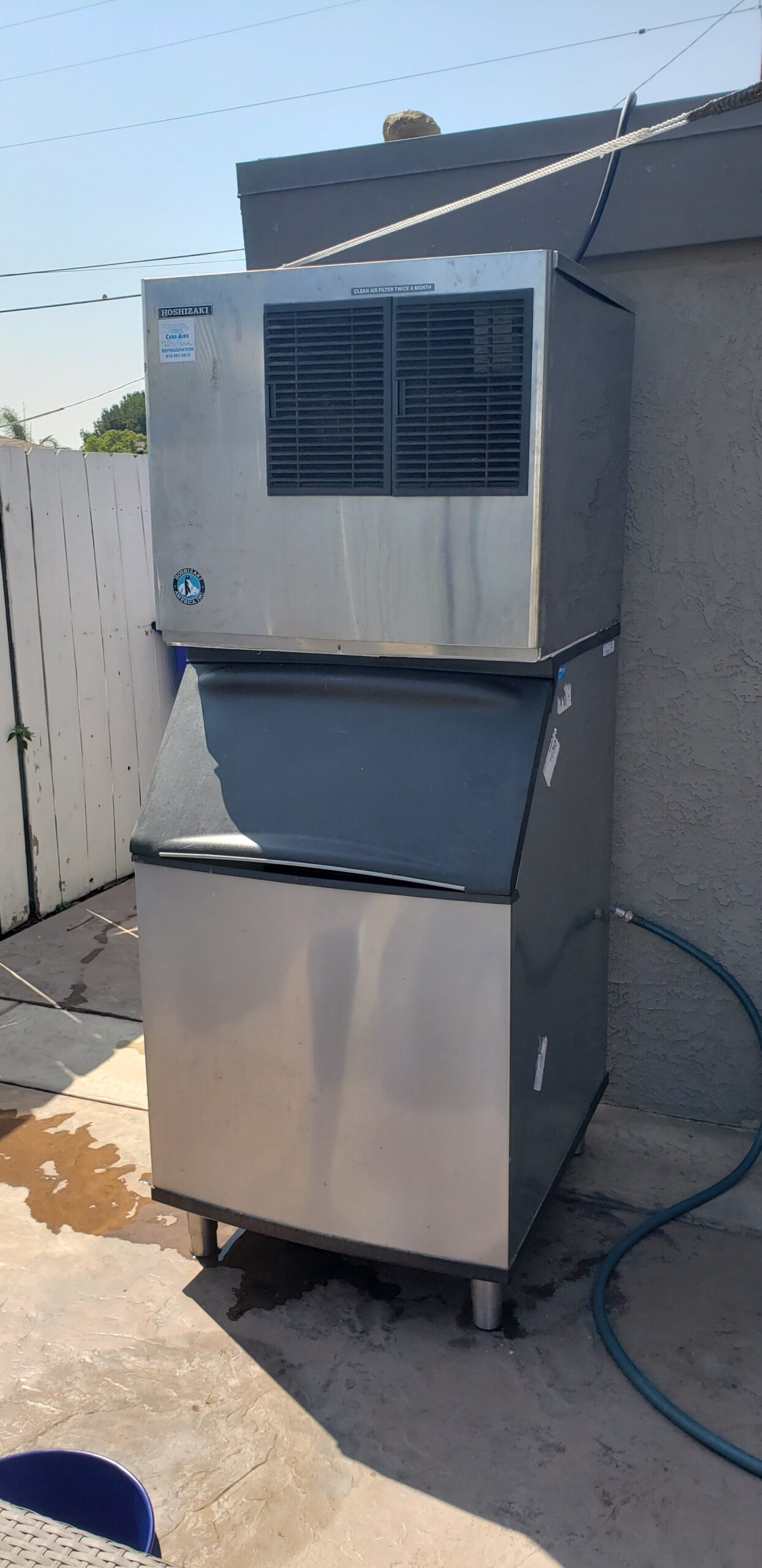Commercial ice-making equipment and storage bin photographed outdoors