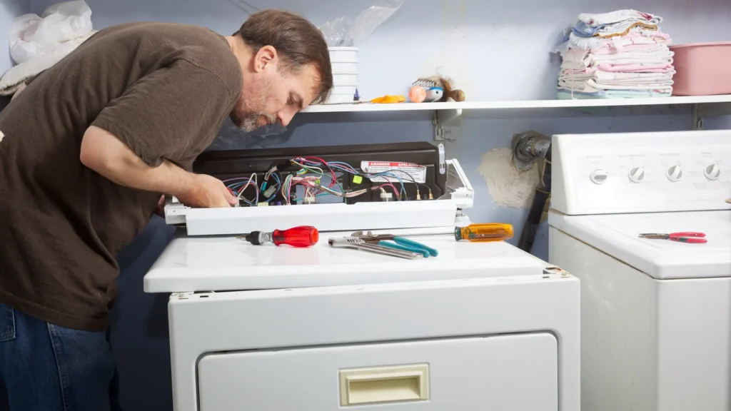 Person working at a dryer with its control panel open