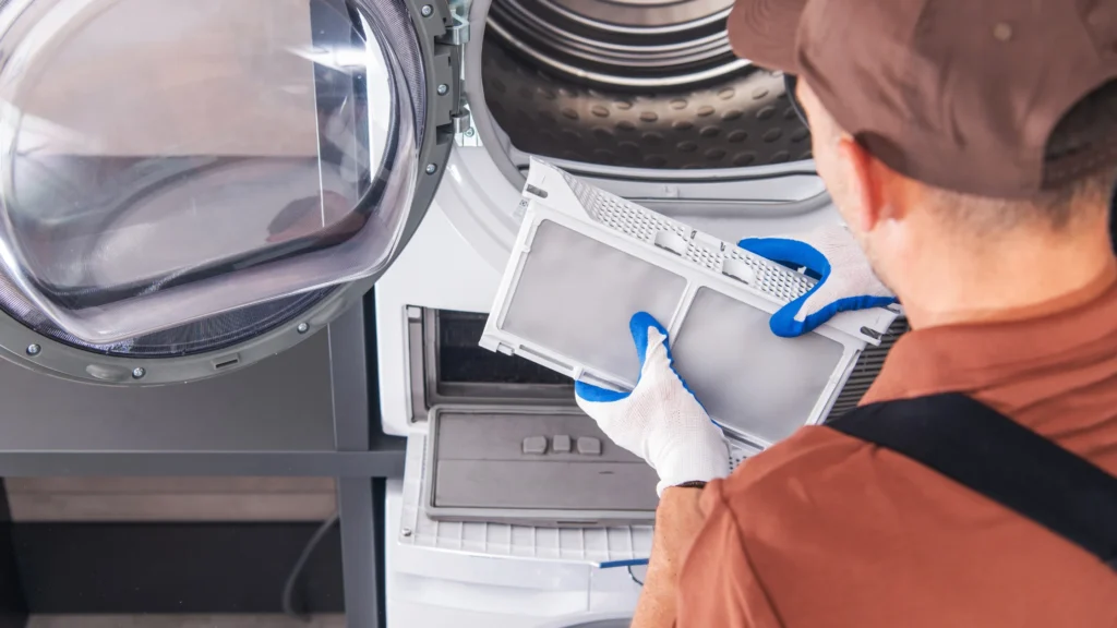Person holding a dryer filter near an open lower compartment