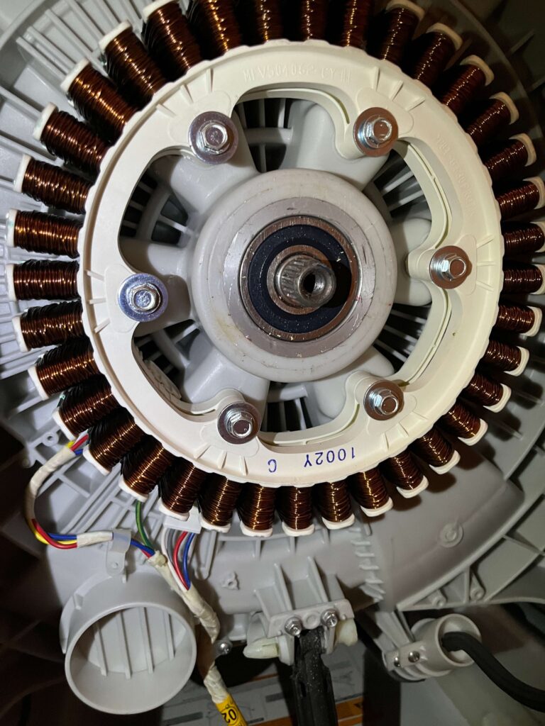 Close-up of a washing machine motor assembly and copper windings